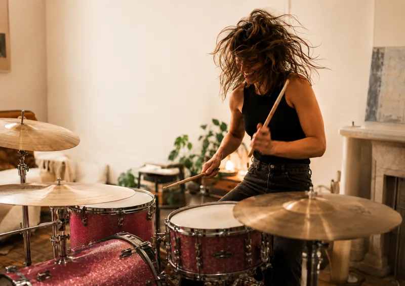 Adult student concentrating while playing drums